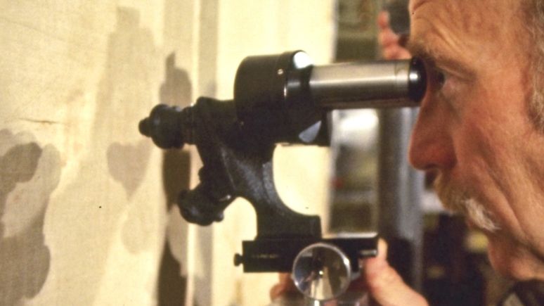 Ein Mann benutzt ein Mikroskop für ein Objekt der Turiner Grabtuch Ausstellung.